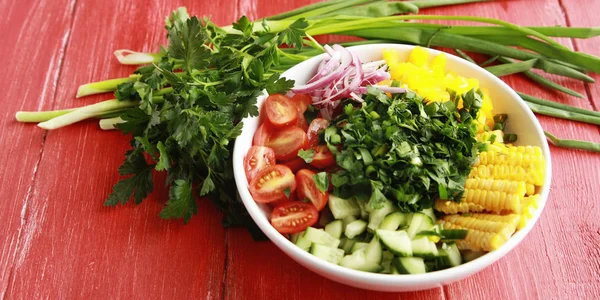 Witte plaat met gesneden groenten voor een vegan-salade. — Stockfoto