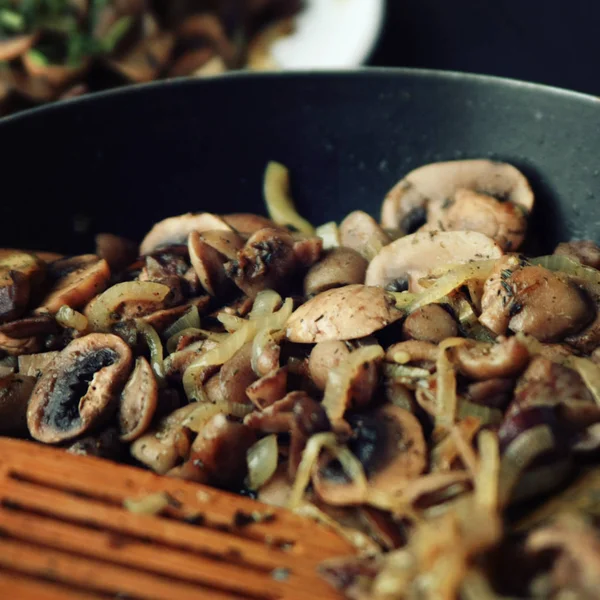 A skillet with a fried mushrooms. Vegan dish.