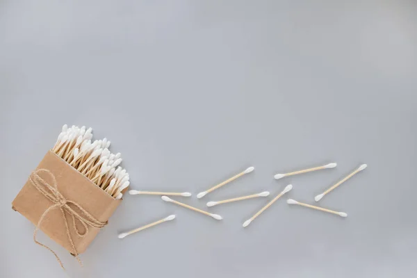 Bambu bomulls pinnar i pappkartong bundna med lin eller hampa rep på grå bakgrund. Kopiera utrymme, mockup, miljövänliga koncept — Stockfoto