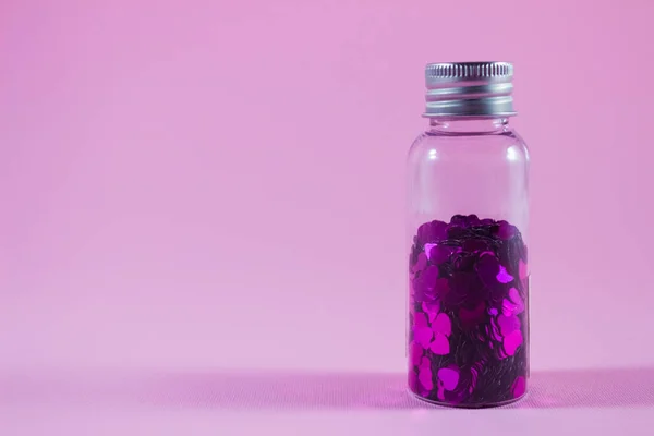 Стеклянная Бутылка Фиолетовыми Блестками Форме Сердца Розовом Фоне Копировальным Местом — стоковое фото