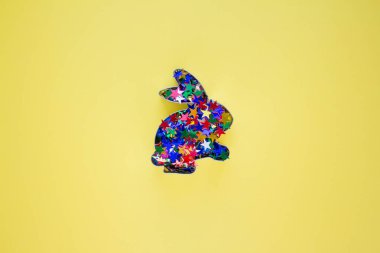 Tavşan şekilli zencefilli çörek ya da renkli yıldızlarla süslenmiş kurabiyeler sarı arka planda parıldıyor ve yaratıcı tasarımın için fotokopi alanı var. Paskalya konsepti