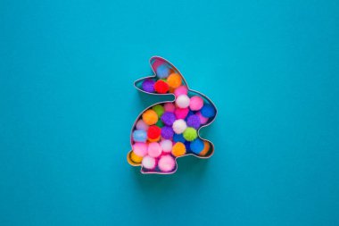 Tavşan şekilli zencefilli çörek için mavi turkuaz arka planda renkli toplar ve fotokopi alanı ile süslenmiş. Paskalya konsepti