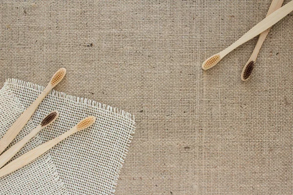 Set of natural toothbrushes on linen fabric background. Sustainable zero waste and lifestyle concept with copy space for your creative design