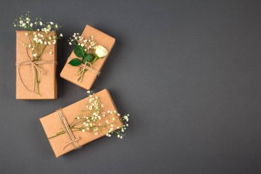 Ekolojik ya da kırsal tarzda geri dönüşümlü kahverengi kraft kağıdı ve keten kablosu ile sarılmış hediye kutuları, metin için kopya alanı ile koyu gri arka planda - doğal eğilimler konsepti..