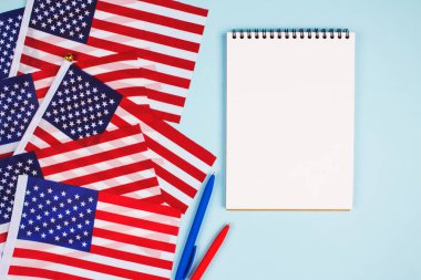Amerikan bayrakları, kırmızı ve mavi kalemler ve açık mavi arkaplanda metin için metin alan boş defterler, ABD 'nin ulusal sembolü Eski Zafer bayrağı. İş veya eğitim kavramı