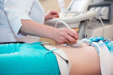 Hastanın karnına ultrason yapan doktorun eli.