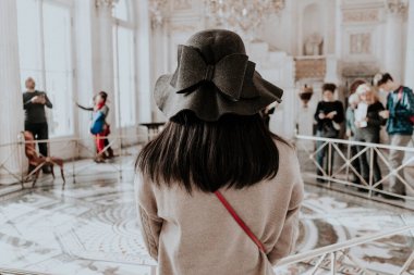 Şapkalı kız müzede yürüyor.