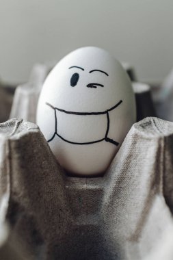 Karton bir kutuda komik yumurtalar. Kahvaltıda yumurta. Koronavirüse karşı komik yumurtalar. Mutlu Paskalyalar için yumurtalar.