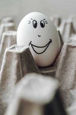 Karton bir kutuda komik yumurtalar. Kahvaltıda yumurta. Koronavirüse karşı komik yumurtalar. Mutlu Paskalyalar için yumurtalar.