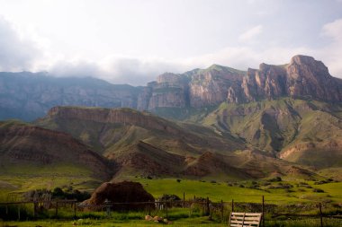 Yüksek dağlar ve yeşil alanlar. Samanlık ve ev işi.