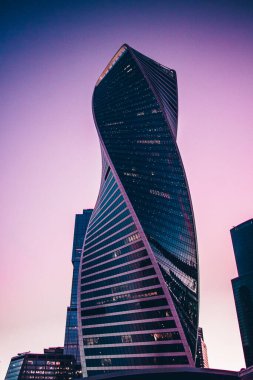 Yüksek gökdelenlerin manzarası. Günbatımı arka planında gökdelenler. Yüksek bina. Şehrin iş merkezi. Modern şehir mimarisi. Cam ve beton evler..