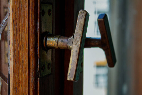 Old handle with a lock in a white door, reflected in the mirror.