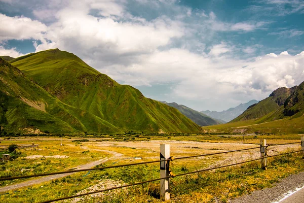 Hoge en groene bergen van Georgië. Zonnige zomer, blauwe lucht. Landschap. — Stockfoto