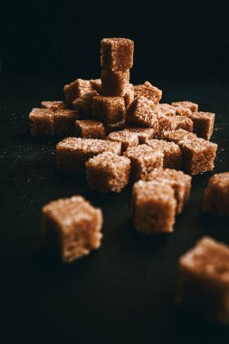 Siyah arka planda kahverengi kamış şekeri. Durgun hayat. 