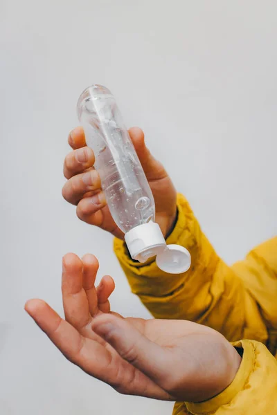 Botol dengan gel di tangan anak-anak. Perlindungan terhadap bakteri. Pengobatan antiseptik. Komposisi alkohol. — Stok Foto