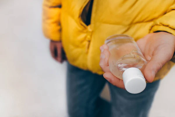 Géllel teli palack gyerekkezekben. Baktériumok elleni védelem. Fertőtlenítő kezelés. Az alkohol összetétele. — Stock Fotó