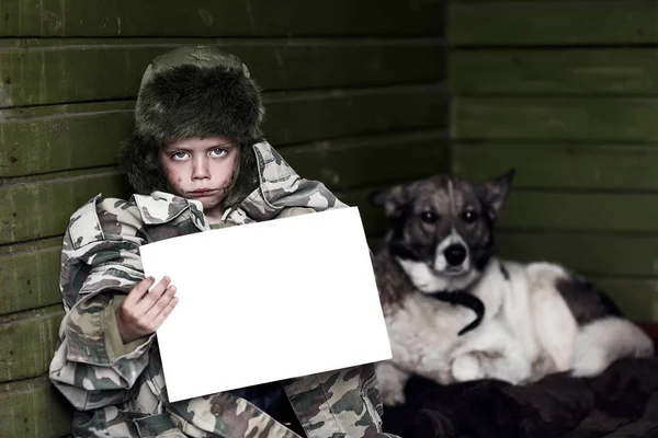 Liten pojke håller tom tallrik och hund — Stockfoto