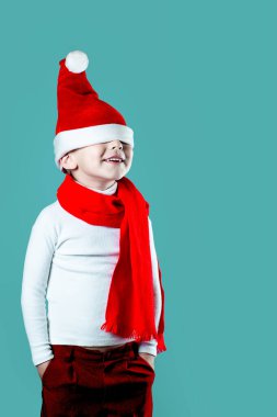 Mutlu küçük Noel Baba şapkası gözlerinin üstüne düştü. Boynuna kırmızı bir eşarp bağlanmış. Mavi bir arkaplanda