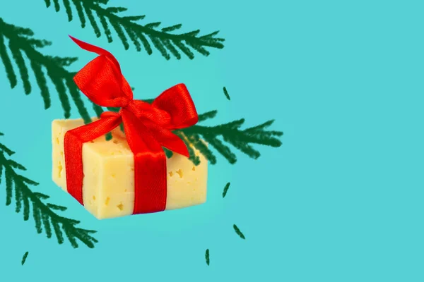Flotando en el aire regalo de queso atado con una cinta roja en las ratas de año nuevo sobre fondo azul — Foto de Stock