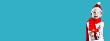 Küçük neşeli Noel Baba nane arkaplanda bir hediye veriyor.