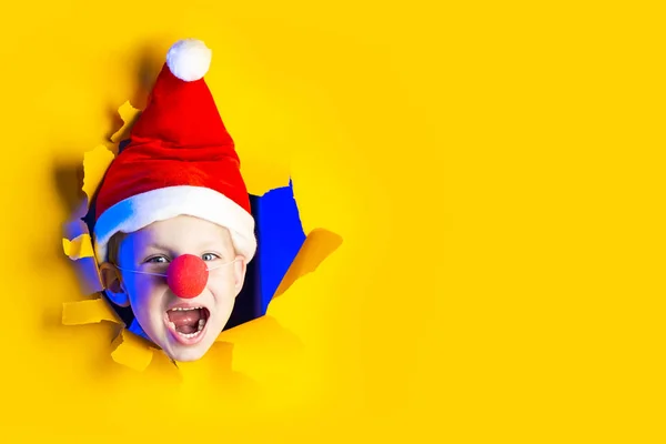 Lidt munter Santa i hat smil, at komme ud af den pjaltede gule baggrund oplyst af neon lys - Stock-foto
