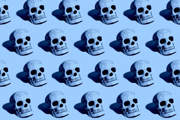 Klassisch blau. Farbe des Jahres 2020. Totenkopf mit hartem Schatten auf blauem Hintergrund lizenzfreie Stockfotos