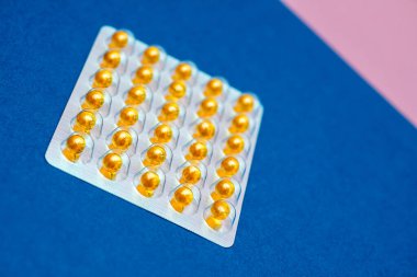 Pembe arka planda balık yağlı su toplayan vitaminler..