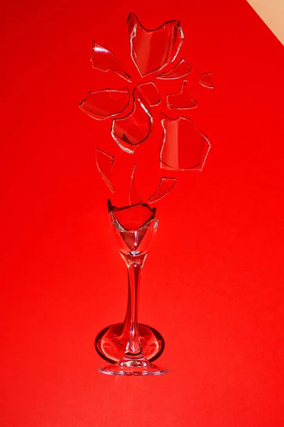 A broken glass on a red background. Heart-shaped shard. — Stock Photo, Image