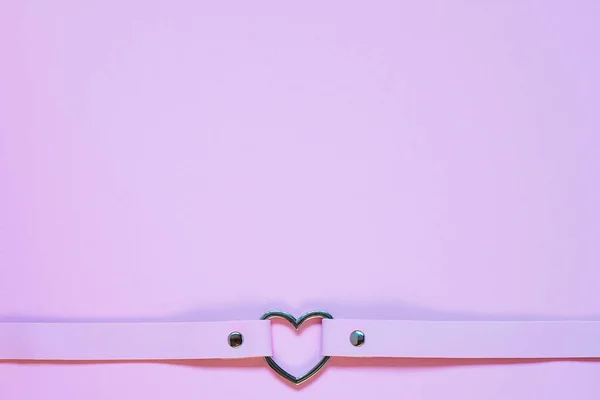 Różowy skórzany dławik z metalowym sercem. Koncepcja Walentynek. — Zdjęcie stockowe
