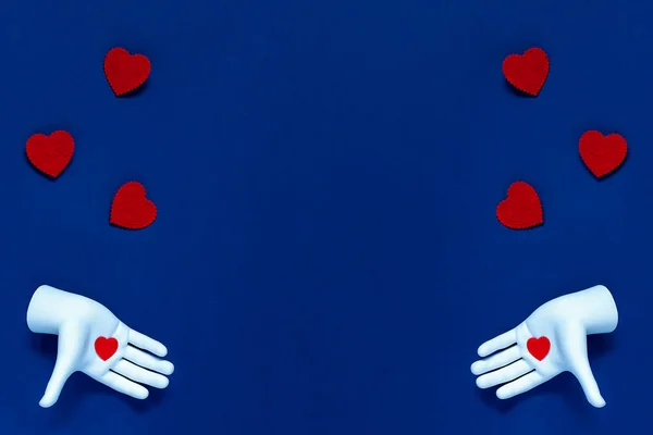 Dwie ręce rzucają czerwone serca na niebieskie tło. Koncepcja Walentynek — Zdjęcie stockowe