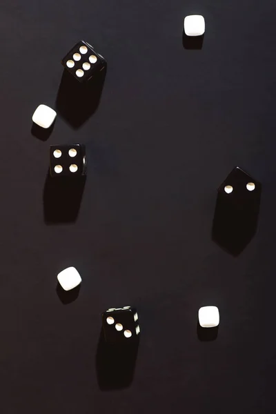 The dice are scattered on a black cloth. Concept.