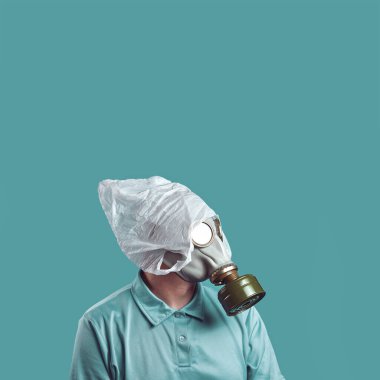 Gaz maskeli bir adam ve kafasında plastik bir torba nane arkaplanındaki kirlilikten çevrenin korunmasını simgeler.