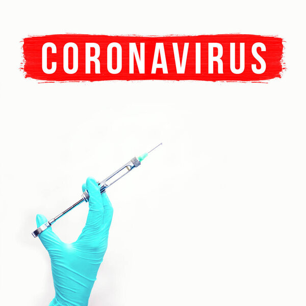 Перчатка с медицинским шприцем. Концепция на тему коронавируса. На светлом фоне
