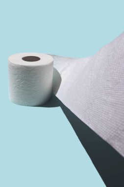 Tuvalet kağıdı kavramı. Katı gölgeli mavi bir arka plana karşı.