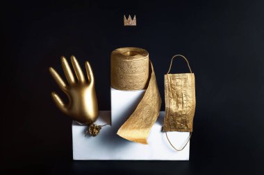 Altın eldiven, tuvalet kağıdı ve maske. Coronavirüs trendleri konsepti. Siyah arkaplan.