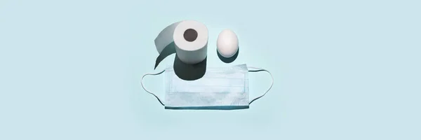 Toiletpapir og æg i stedet for øjne. En medicinsk maske. Koncept om temaet påske og coronavirus - Stock-foto