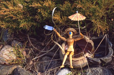 Tahta adam karantinanın kaldırılmasından sonra vahşi doğaya gitti. Maskesini çıkardı ve güneşlendi. Salgının teması üzerine bir konsept.