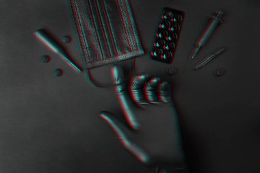 Virüsün düğmesi. Eldiven, maske, tablet, şırınga, şişeler koyu bir arka planda yatıyor..