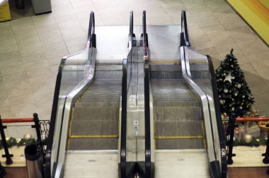 Büyük, modern bir binanın içinde yürüyen merdiven.