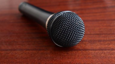 Karaoke söylemek için siyah mikrofon ahşap bir yüzeyde yatar.