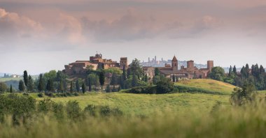 Scenic panorama of medieval village of Certaldo old town, Italy, with San Gimignano towers in the background, typical Italian and Tuscany countryside landscape   clipart