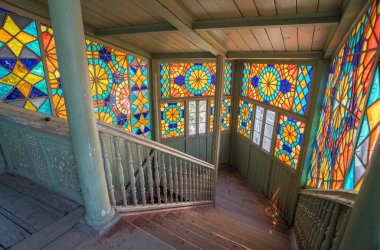 Tbilisi, Georgia - July 2019: Interior of famous traditional old wood Georgian house with colorful stained glass windows and wooden staircase