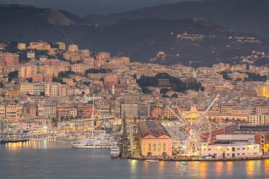 Genova, Genoa, Italy - January 2019: Beautiful aerial view of Genoa port harbor, Magazzini del cotone, Porto Antico, sea and Ferris wheel at dusk. Cityscape photography