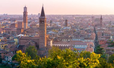 Verona, Italy: Beautiful sunset aerial view of old town of Verona, Torre Lamberti and Santa Anastasia bell tower from Piazzale Castel S. Pietro. Cityscape, skyline