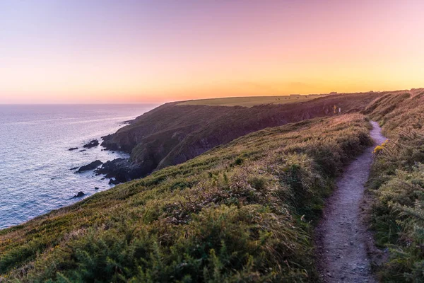 Güzel manzaralı gün batımı manzaralı Ballycotton uçurumu yürüyüşü, County Cork, İrlanda, alacakaranlıkta, sakin deniz, güneş batarken ufuk çizgisi, yalnız yol, popüler yürüyüş yolu, alacakaranlık, okyanus