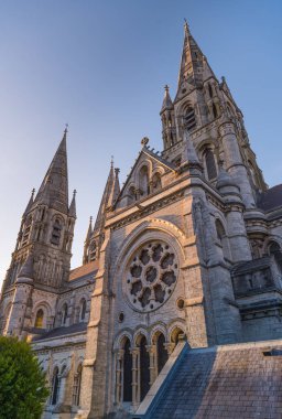 Cork, Ireland  September 2019: Beautiful scenic sunset view of Saint Fin Barre's Cathedral, a Gothic Revival three-spire cathedral, at dusk