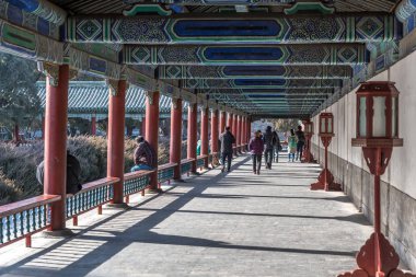 Pekin, Çin - Ocak 2018: Turistler ve yerliler Cennetin Tapınağı 'na giden renkli sütunlar ve fenerlerle kaplı ahşap bir oyun salonu boyunca yürüyorlar (Tian Tan Tapınağı))