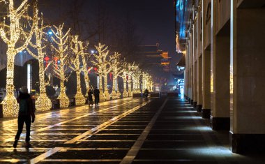 Xian, Xian, China - January 2018: Beautiful urban scene, road lined with illuminated trees by night during Christmas season, Xmas decorations and Christmas lights