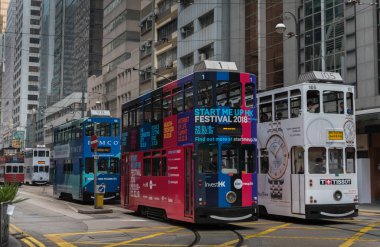 Sheung Wan, Hong Kong, Çin - Ocak 2018: modern gökdelenlere karşı renkli çift katlı tramvayları olan Hong Kong şehir merkezi yolu