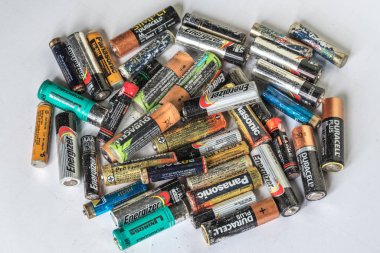 Genova, Italy - May 2019: Heap of colorful dead used old single use disposable and rechargeable AA and AAA batteries with manufacturer brand visible. Hazardous waste recycle concept